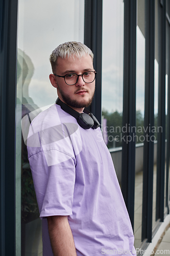 Image of In front of a modern glass building, a young, blond influencer strikes a confident pose, epitomizing urban glamour and style in the heart of the city