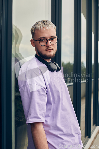 Image of In front of a modern glass building, a young, blond influencer strikes a confident pose, epitomizing urban glamour and style in the heart of the city