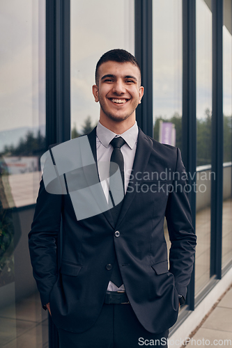 Image of A CEO dressed in a sleek black suit stands confidently at the entrance of a modern corporate building, awaiting the start of the workday in the bustling urban environment.