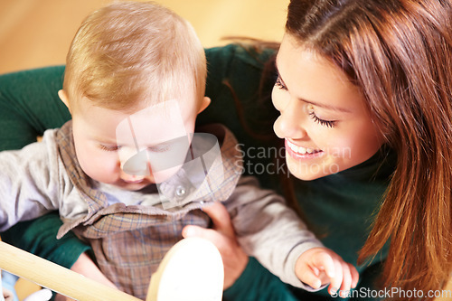 Image of Mother, holding and baby with smile for child development with toys for future, growth or milestone in home. Woman, infant or family in living room for bond in relationship with love, care or support