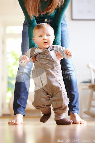 Image of Mother, baby and face with help for walking in home for motor skills, development or milestone with assistance. Son, toddler and excited for mobility, movement or freedom in living room with support