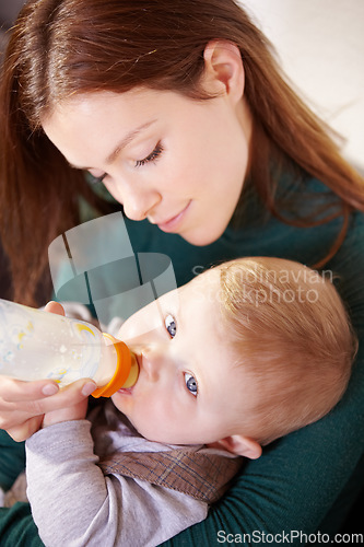 Image of Face, woman and holding of baby with bottle for feeding in home for health, diet and nutrition with formula for hunger. Mother, watch and son for growth, development or milestone for future with care