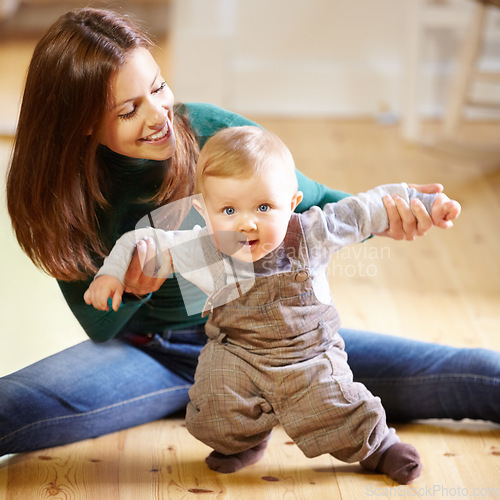 Image of Mother, baby and smile for help with standing for development, motor skills or walking with assistance. Boy, infant or toddler with excited expression on face for future growth, milestone and support