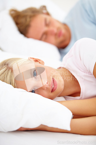 Image of Portrait, wake up and a couple in bed in the morning to relax in their home together on the weekend. Face, sleep or rest and a young woman in the bedroom with her boyfriend for honeymoon bonding