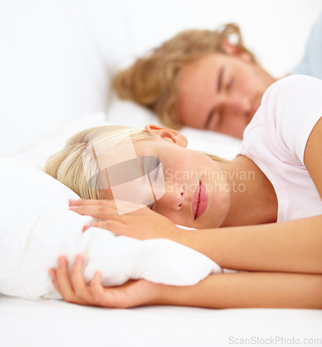 Image of Face, sleep and a couple in bed in the morning to relax in their home together for holiday or vacation. Love, dreaming or eyes closed with a young woman and man in the bedroom of their apartment