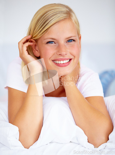 Image of Portrait, smile and relax with a woman on her bed for the weekend to rest or chill during time off. Face, wake up and a happy young person alone in the bedroom of her home or apartment to refresh