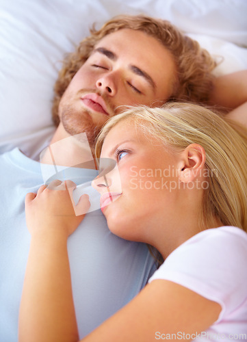 Image of Face, thinking and love with a couple in bed together to relax in the morning or to wake up in their home. Peace, marriage and young woman lying on the chest of her boyfriend in the apartment bedroom