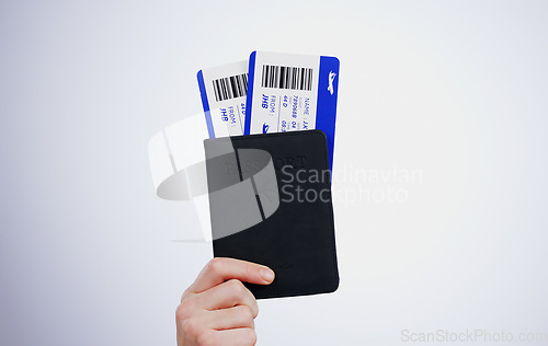 Image of Hand, passport and flight tickets for travel closeup in studio on a gray background at the airport for a trip. Boarding pass, documents for immigration and a passenger getting ready for departure