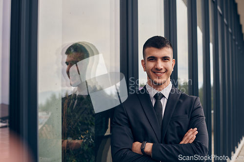 Image of A CEO dressed in a sleek black suit stands confidently at the entrance of a modern corporate building, awaiting the start of the workday in the bustling urban environment.