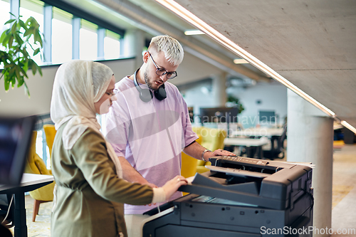 Image of In a modern startup office, a business-minded Muslim woman wearing a hijab collaborates with her colleague, symbolizing diversity, empowerment, and success in the contemporary corporate world