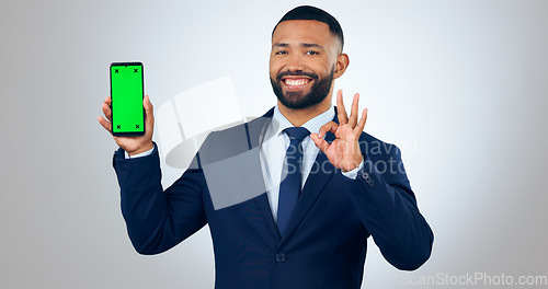 Image of Phone, green screen portrait of and business man with okay sign in studio for approve, website and social media. Corporate, hand gesture and person on smartphone for mobile app on gray background