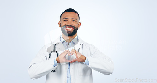 Image of Portrait, doctor with heart hands and smile in studio for care, kindness and trust icon in healthcare. Support, love emoji and help medical professional man showing happiness on white background.