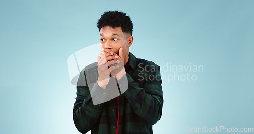 Image of Wow, surprise and hands on face of man in studio with shocking, news or info on blue background. Omg, gossip and male model with emoji reaction or drama, announcement or secret, giveaway or promotion