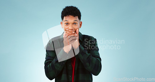 Image of Surprise, shock and hands on face of man in studio with wow, news or announcement on blue background. Omg, portrait and male model with emoji gesture for unexpected results, feedback or secret gossip