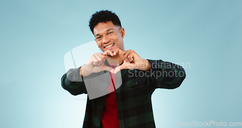 Image of Heart, hands and portrait of man in studio with support, vote or feedback on blue background. Love, face and male model with finger frame for donation, charity or gratitude, appreciation or thank you