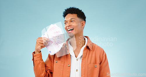 Image of Happy man, winner and money fan with success, bonus or winning, college loan or cashback ideas in studio. Excited student thinking of cash, savings or scholarship funding isolated on blue background