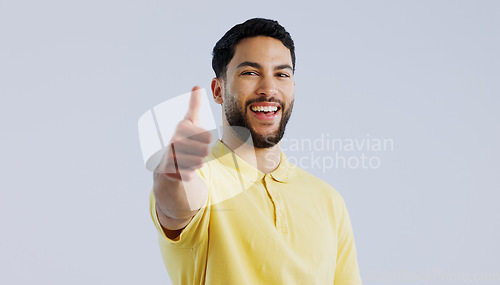 Image of Thumbs up, portrait and man in studio for agreement, winning achievement and celebrate deal on white background. Happy indian model, emoji and like sign for feedback, yes and thank you for excellence