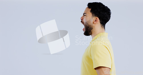 Image of Scream, angry and man in studio at mockup space for crisis, conflict and mad emoji reaction on white background. Profile of frustrated indian model shouting with stress, anger and negative expression