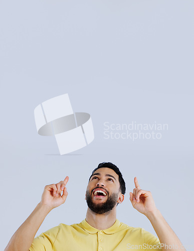 Image of Man, smile and pointing up to space in studio for advertising choice, decision or launch information on white background. Excited indian model, thinking and show presentation of mockup, ideas or news