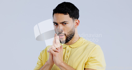 Image of Finger gun, serious and portrait of man in studio with aim for target, shooting and spy on blue background. Secret agent, security mockup and face of person with hand gesture for pistol or weapon