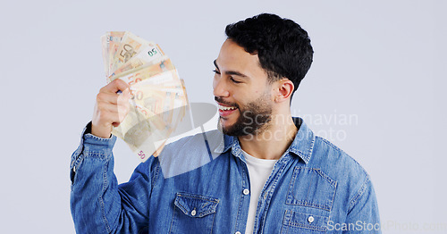 Image of Man, money fan and smile in studio with thinking for financial freedom, goals and decision with success by background. Person, ideas and winner with bonus cash, revenue or excited for salary increase