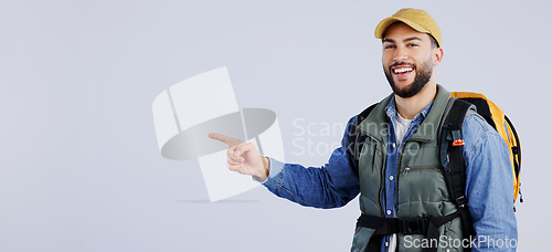 Image of Happy man, backpack and pointing on mockup for travel, adventure or hiking tips against a studio background. Banner of male person or hiker smile with bag showing trekking list, deal or advertising