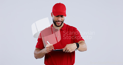 Image of Happy man, delivery and writing on clipboard for signature, order or form against a studio background. Male person or guy in courier service smile for filling paperwork, legal document or agreement