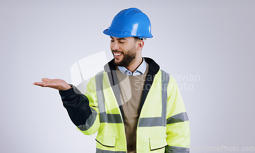 Image of Happy man, architect and palm for advertising or marketing against a gray studio background. Male person, contractor or engineer smile with hard hat and hand out for deal or service in construction