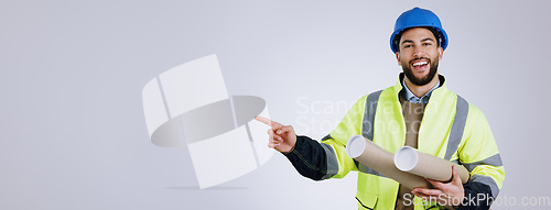 Image of Portrait, pointing and man engineer with blueprint in studio with mockup space for advertising. Happy, smile and male industrial worker with architect designs and show hand gesture by gray background