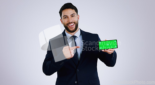 Image of Business man, phone green screen and pointing to presentation, announcement or news in studio. Portrait of corporate worker with mobile app, career opportunity or website mockup on a white background