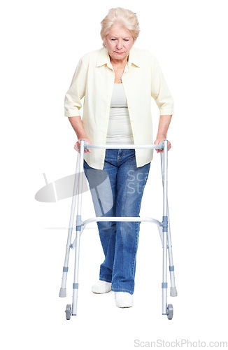 Image of Taking it one step at a time ...Full-length of a senior woman focusing on pushing her walker while isolated on white.