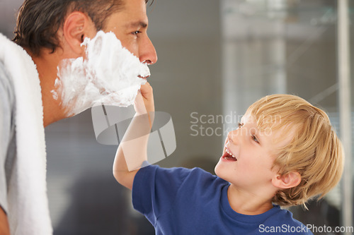 Image of Giving him a clean shave. A young boy shaving his fathers beard.