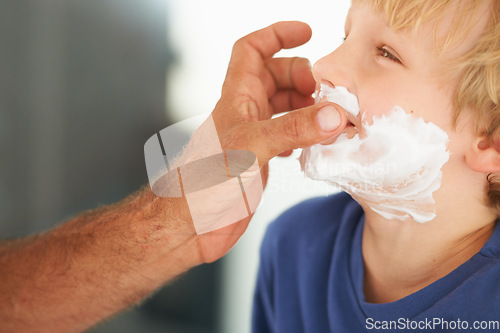 Image of Showing him the ropes of shaving. A father playfully putting shaving cream on his sons face.