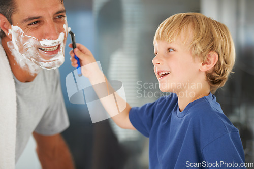 Image of A good clean shave. A young boy shaving his fathers beard.