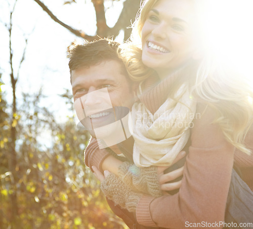 Image of Having fun in the woods. A happy man piggybacking his girlfriend while spending time in the woods.