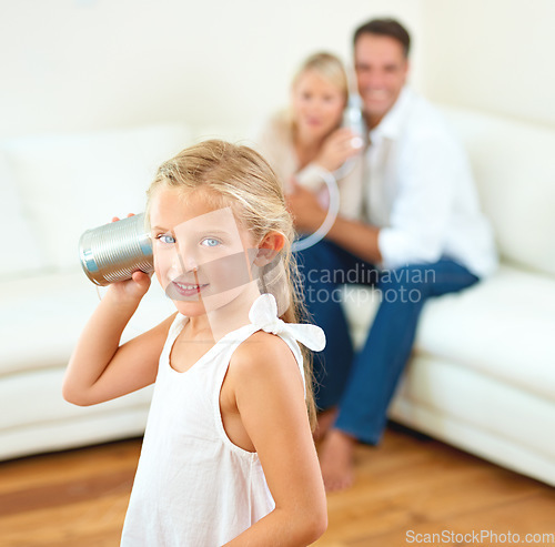 Image of You have my number. A little girl listening through a tin can connected to her parents in the background.