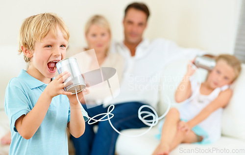 Image of Can you hear me now. A little boy shouting loudly into a tin can connected to another that his sister is holding.