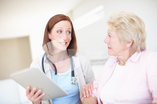 Image of Reassurance in trying times - Senior Health. Mature nurse explains the outcome of her elderly patients medical tests.