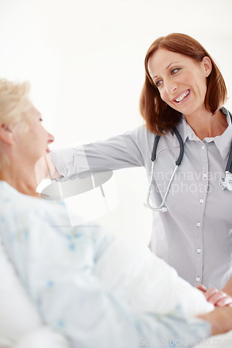 Image of Conscientious healthcare for the elderly. Mature doctor pays her elderly female patient a visit following an operation.