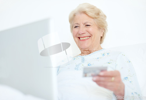 Image of Keeping up with payments is a weight off her shoulders. Elderly hospital patient prepares to make a purchase off of the internet with her credit card.