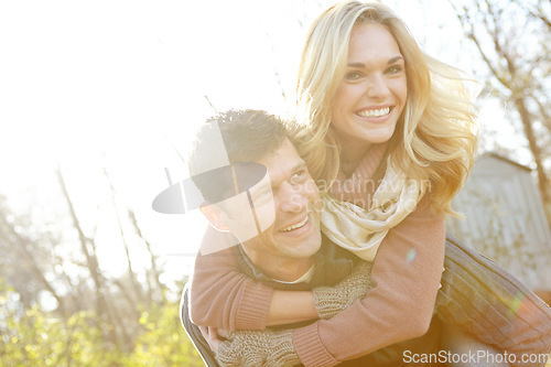 Image of He loves to make her smile. A happy man piggybacking his girlfriend while spending time in the woods.