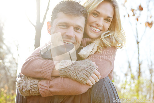 Image of Enjoying a warm embrace. A happy man piggybacking his girlfriend while spending time in the woods.