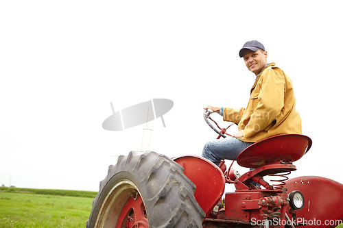 Image of This is my job and I love it. Rearview of a smiling farmer driving his tractor on an open field with copyspace.