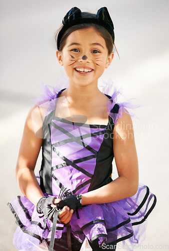 Image of Ready for a little trick or treating. Little girl dressed in a Halloween costume while smiling.