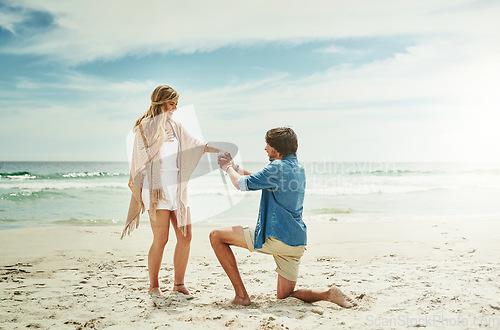 Image of Will you make me the happiest man in the world. Full length shot of a young man proposing to his girlfriend on the beach.