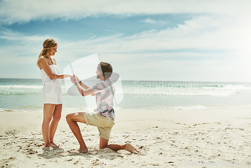 Image of Will you be my wife. Full length shot of a young man proposing to his girlfriend on the beach.