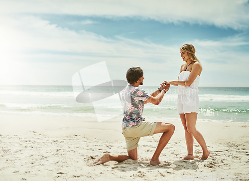 Image of I want to spend the rest of my life with you. Full length shot of a young man proposing to his girlfriend on the beach.