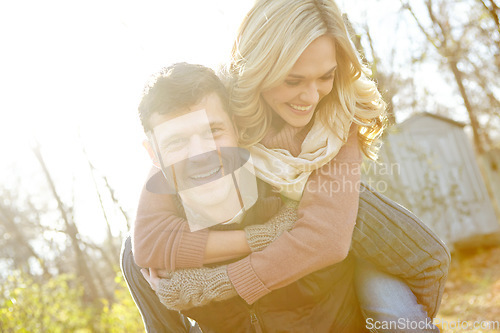 Image of He loves to make her laugh. A happy man piggybacking his girlfriend while spending time in the woods.
