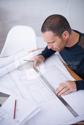 Image of Checking his work to ensure the highest standard. High angle shot of an architect drafting up building plans.