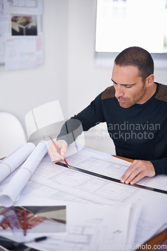 Image of He takes great pride in the accuracy of his work. an architect drafting up building plans.